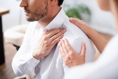 Masöz görüşü bulanık ön planda ofisteki işadamının acı dolu omzuna dokunuyor.