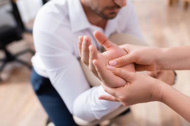 Masöz görüntüsü bulanık arka planda iş adamı palmiyesine masaj yapıyor.