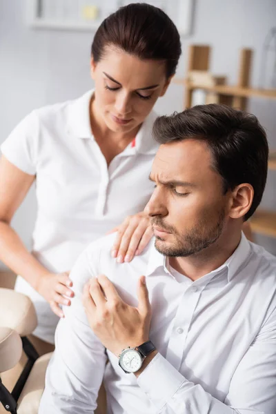 Masseuse Massaging Aching Shoulder Businessman Office Blurred Background — Stock Photo, Image