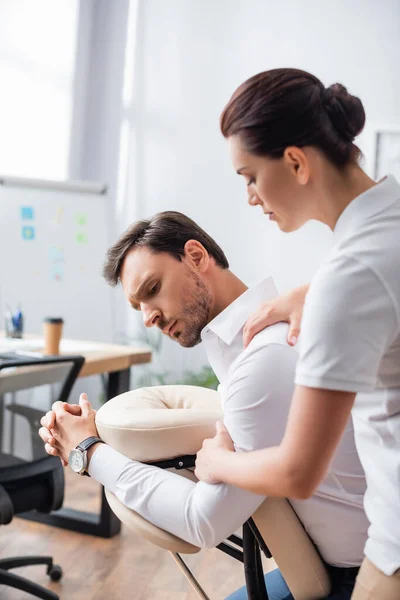 Massagista Fazendo Massagem Sentada Empresário Ombro Escritório Fundo Borrado — Fotografia de Stock