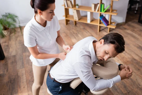 Hoge Hoek Uitzicht Masseuse Doen Zittende Massage Van Zakenman Terug — Stockfoto