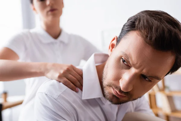 Close View Serious Businessman Looking Away While Masseuse Massaging Shoulders — Stock Photo, Image