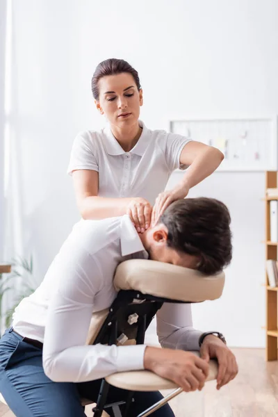 Masseurin Massiert Nacken Eines Geschäftsmannes Auf Massagesessel Büro Vor Verschwommenem — Stockfoto