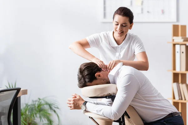 Feliz Massagista Fazendo Massagem Pescoço Para Homem Negócios Escritório Fundo — Fotografia de Stock