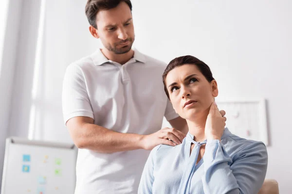 Masajista Enfocado Masajeando Lastimando Hombro Cliente Femenino Con Mano Cuello — Foto de Stock