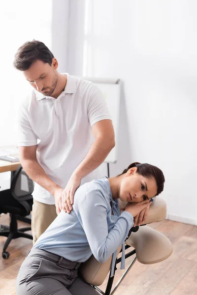 Massagista Massageando Costas Empresária Sentada Cadeira Massagem Escritório Fundo Turvo — Fotografia de Stock