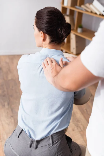 Massagetherapeut Tut Sitzende Massage Der Geschäftsfrau Schulter Auf Verschwommenem Vordergrund — Stockfoto