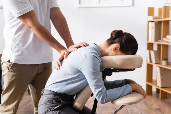 Vista Lateral Massagista Fazendo Massagem Sentada Costas Para Empresária Morena — Fotografia de Stock