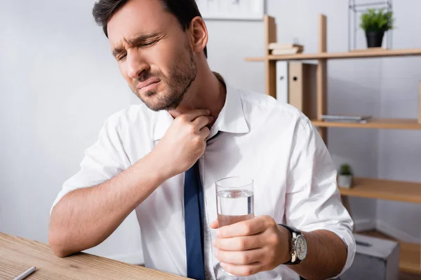 Empresario Con Mano Cuello Sosteniendo Vaso Agua Mientras Está Sentado —  Fotos de Stock