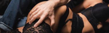 Çoraplı, afişli, seksi kız arkadaşının bacağına dokunan adamın görüntüsü. 