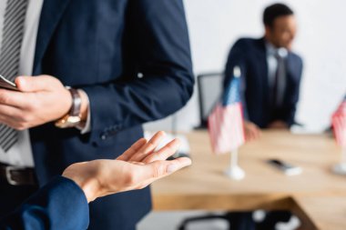 woman gesturing near colleague during party congress on blurred background clipart