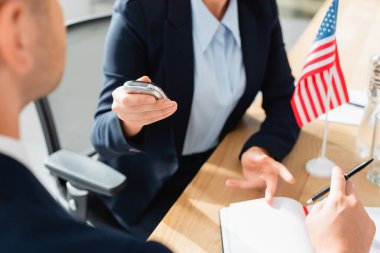 partial view of journalist with dictaphone interviewing politician during press conference on blurred background clipart