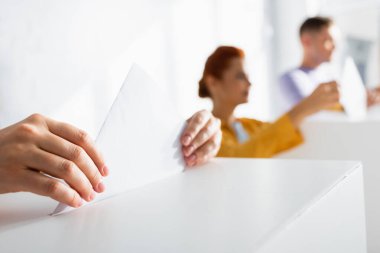 Seçmenler bulanık arkaplanda sandık başına oy veriyorlar