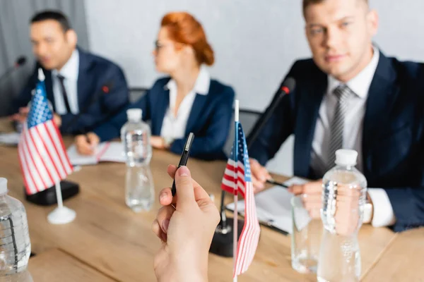 Politician Pointing Pen Table Boardroom Blurred Colleagues Background — Stock Photo, Image
