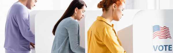 voters in polling cabins with american flag and vote lettering on blurred background, banner