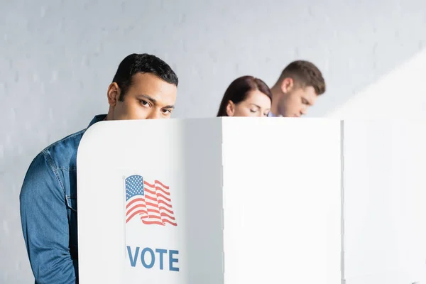 Hombre Indio Mirando Cámara Desde Cabina Votación Cerca Electores Multiculturales — Foto de Stock