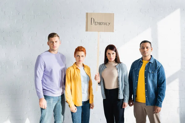 Serious Multicultural People Looking Camera While Holding Placard Democracy Lettering — Stock Photo, Image