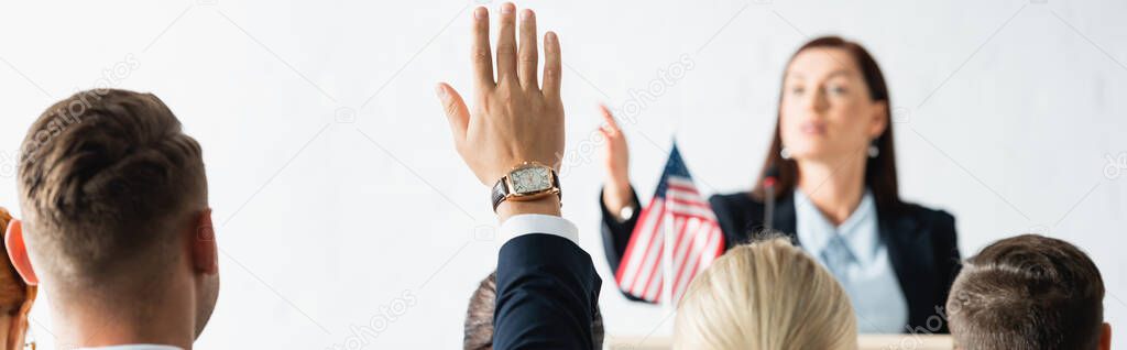 political agitator pointing with hand at voters in conference hall on blurred background, banner