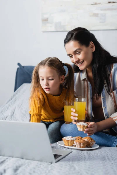 Mamma Och Dotter Med Muffins Och Apelsinjuice Titta Film Laptop — Stockfoto