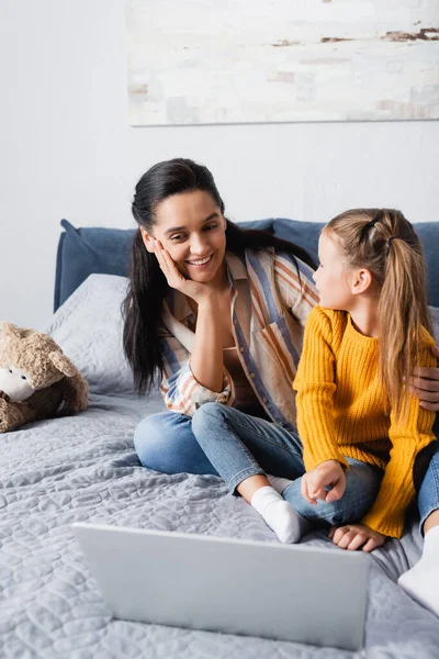 Feliz Madre Hija Mirándose Mientras Están Sentadas Cama Cerca Computadora — Foto de Stock