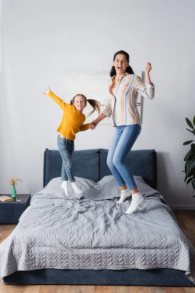 Aufgeregte Mutter Und Tochter Springen Vor Laufender Kamera Auf Bett — Stockfoto