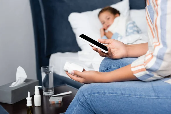 Anya Gazdaság Üveg Tablettát Mobiltelefon Közelében Beteg Lánya Fekszik Ágyban — Stock Fotó