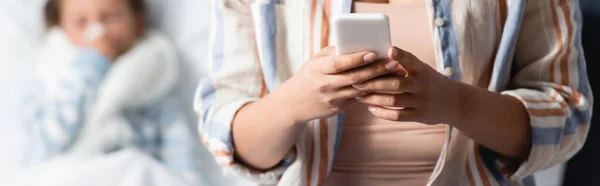 Mother Messaging Smartphone Sick Daughter Lying Bed Blurred Background Banner — Stock Photo, Image