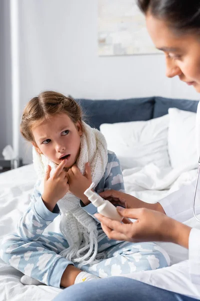 Άρρωστο Κορίτσι Δείχνει Στο Ανοιχτό Στόμα Ενώ Γιατρός Κρατώντας Σπρέι — Φωτογραφία Αρχείου