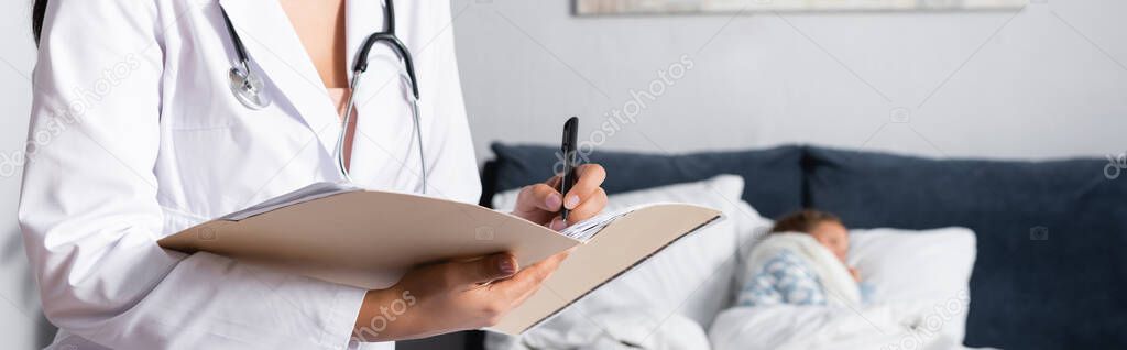 pediatrician writing diagnosis near diseased child lying in bed, banner