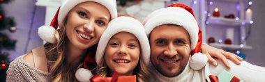 Mutlu aile Noel 'de kameraya bakıyor, afiş