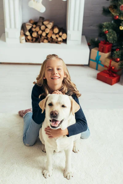 Boldog Lány Meleg Pulóver Ölelés Labrador Díszített Nappaliban Karácsonyi Koncepció — Stock Fotó