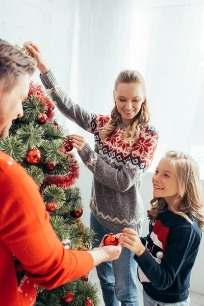 Šťastný Dítě Zdobení Vánoční Stromeček Radostnými Rodiči Doma — Stock fotografie