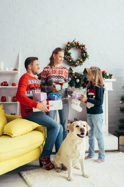 Joyful Parents Holding Gifts Daughter Dog Decorated Living Room — Stock Photo, Image