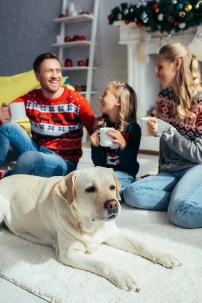 Perro Cerca Alegre Familia Sosteniendo Tazas Sobre Fondo Borroso —  Fotos de Stock