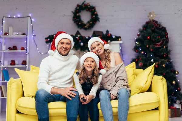 Glückliche Familie Mit Weihnachtsmützen Blickt Dekorierte Wohnzimmer Die Kamera — Stockfoto