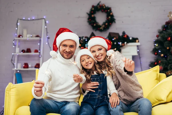 Lycklig Familj Santa Hattar Som Håller Tomtebloss Dekorerat Vardagsrum Jul — Stockfoto