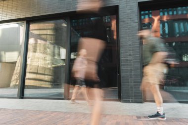 citizens walking on modern street near building, long exposure clipart