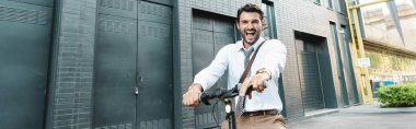 Hayretler içindeki iş adamı elektrikli scooter ve pankart kullanıyor.