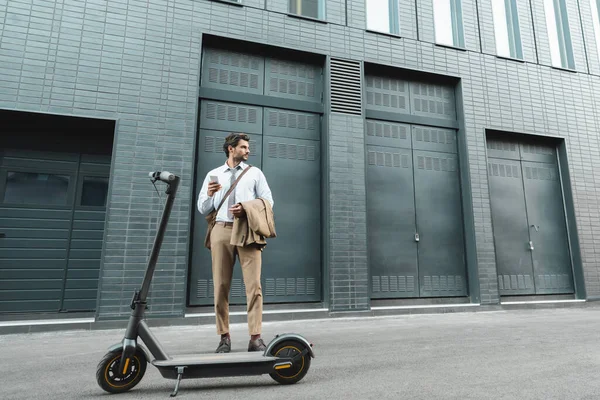 Full Length Businessman Holding Smartphone While Standing Scooter Building — Stock Photo, Image