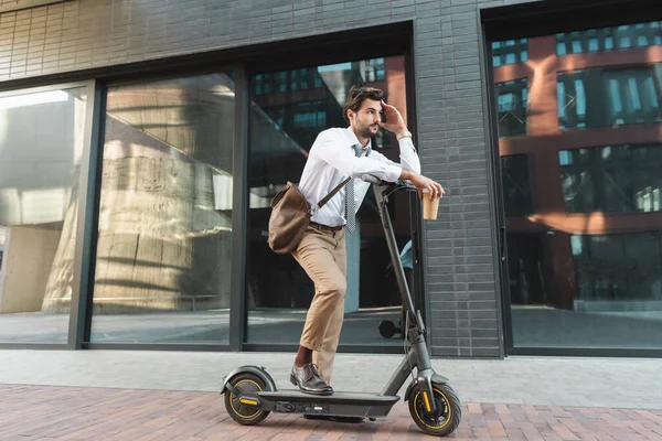 Nachdenklicher Geschäftsmann Auf Roller Hält Papierbecher Auf Straße — Stockfoto