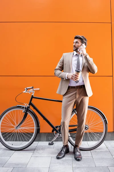 Intera Lunghezza Uomo Affari Parlando Smartphone Tenendo Tazza Carta Vicino — Foto Stock