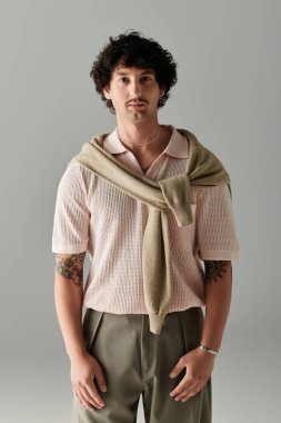 Yakışıklı genç adam kendine güveni tam, modern giysileri ve şık cazibesini içeride sergiliyor..