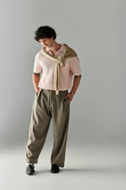 Yakışıklı genç bir adam modaya uygun giyinmiş, modern moda havasını somutlaştırıyor..