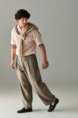 Modayı takip eden genç bir adam zarif bir şekilde yürür, şık kıyafetler giyer, cazibe ve tarz yayar..