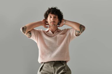 Yakışıklı bir genç kasıtlı bir zarafetle poz veriyor. Benzersiz moda anlayışını sergiliyor..