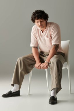 Rahat duruşu olan şık bir genç adam stüdyoda çağdaş modaya dikkat çekiyor..