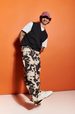 Tarz sahibi genç bir adam modaya uygun giyinerek modern moda seçimlerini ön plana çıkarıyor..