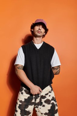 Yakışıklı erkek manken modaya uygun bir şekilde poz veriyor, benzersiz moda anlayışını sergiliyor..