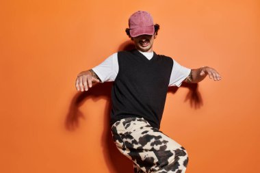 Şık genç adam modaya uygun bir ortamda neşeli bir cazibe sergiliyor..