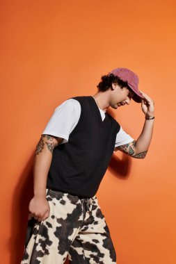 Yakışıklı genç adam moda anlayışını parlak bir ortamda eşsiz bir kıyafetle sergiliyor..